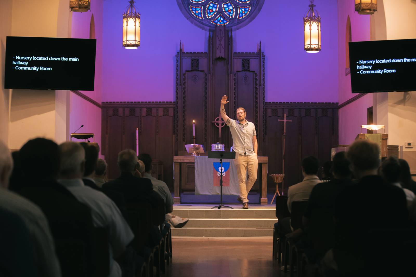 Pastor mid-sermon with the congregation and rose window